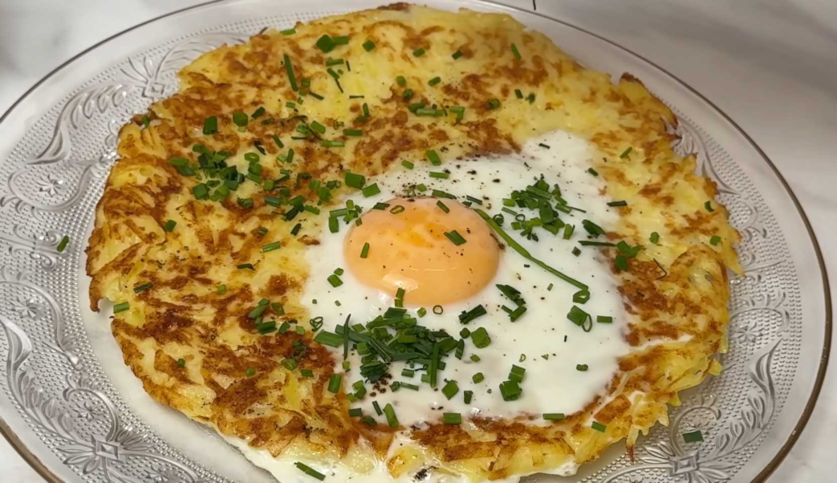 Изображение блюда: Хрустящий картофельный блин с яйцом-глазуньей в центре — Eda.Video