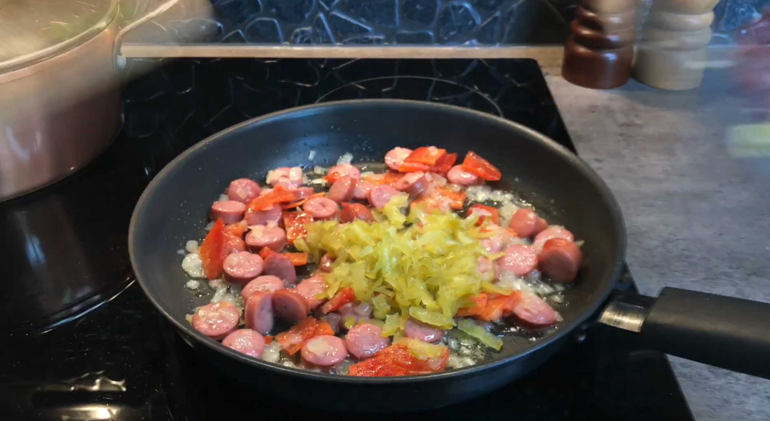 Натираем на терке огурец и добавляем его в сковороду. Солянка на сковороде-Шаг 4