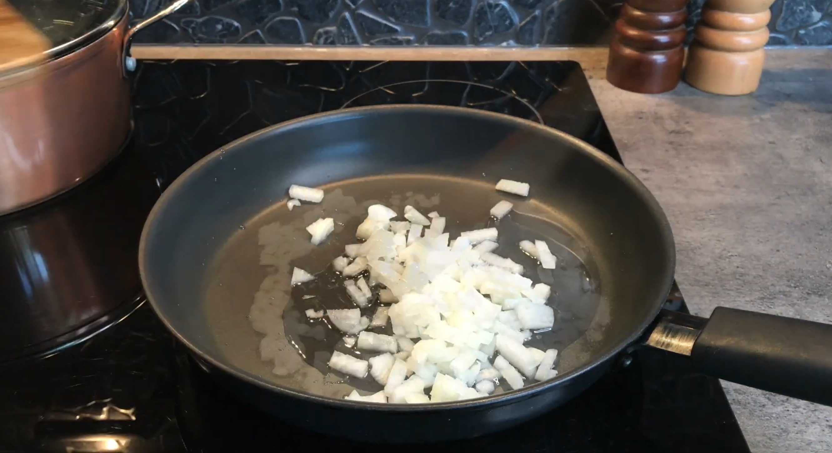 Обжариваем лук до мягкости, помешивая на сковороде Солянка на сковороде-Шаг 2