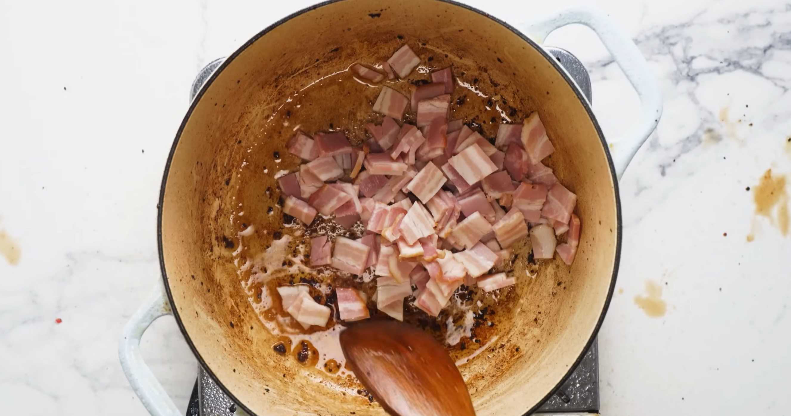 Выложите в ту же кастрюлю мелко нарезанный бекон, обжарьте и переложите в миску к мясу. Семейный мясной пирог-Шаг 3