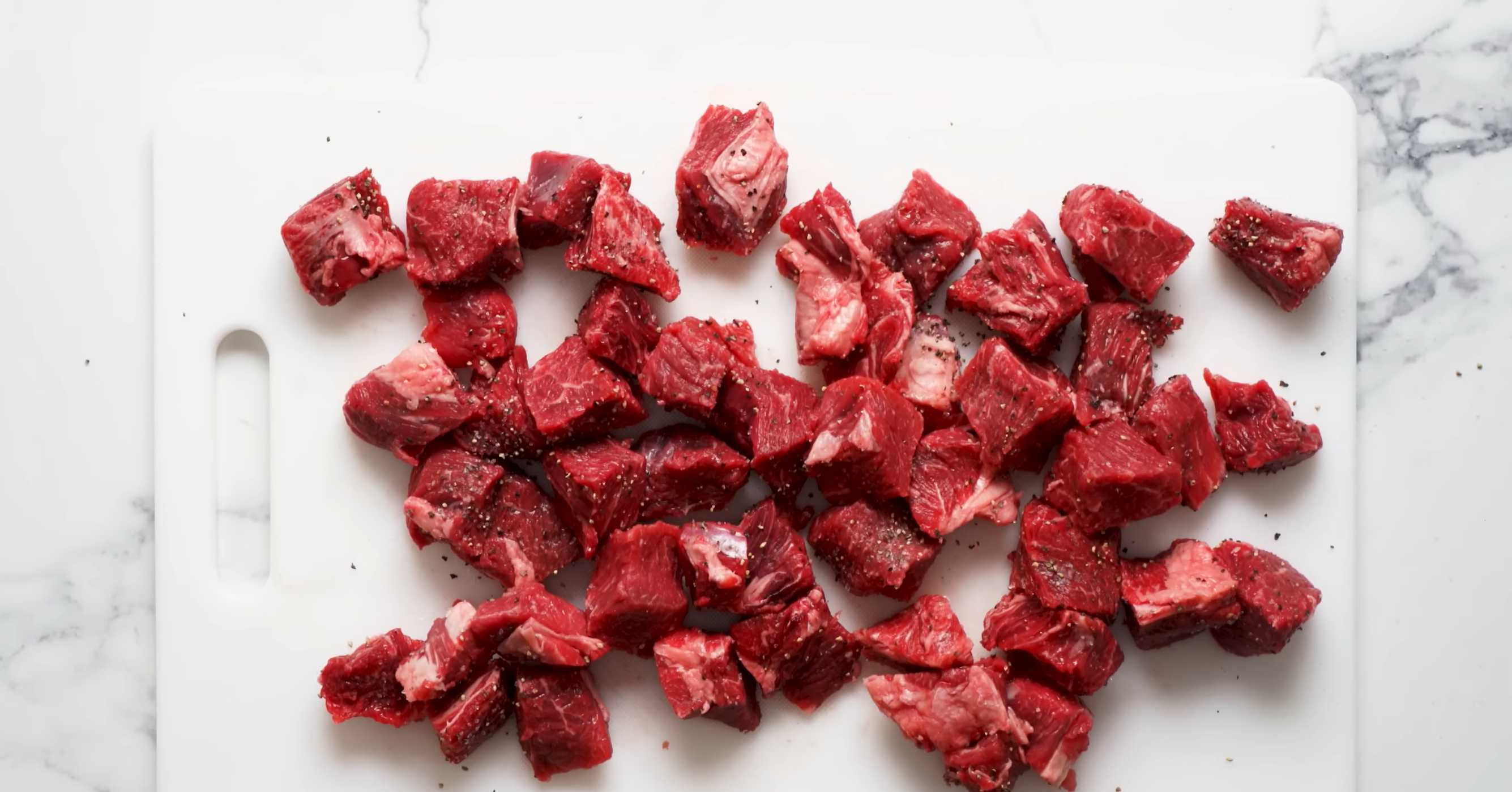 Нарежьте говядину мелкими кусочками, посолите, поперчите и перетрите. Семейный мясной пирог-Шаг 1