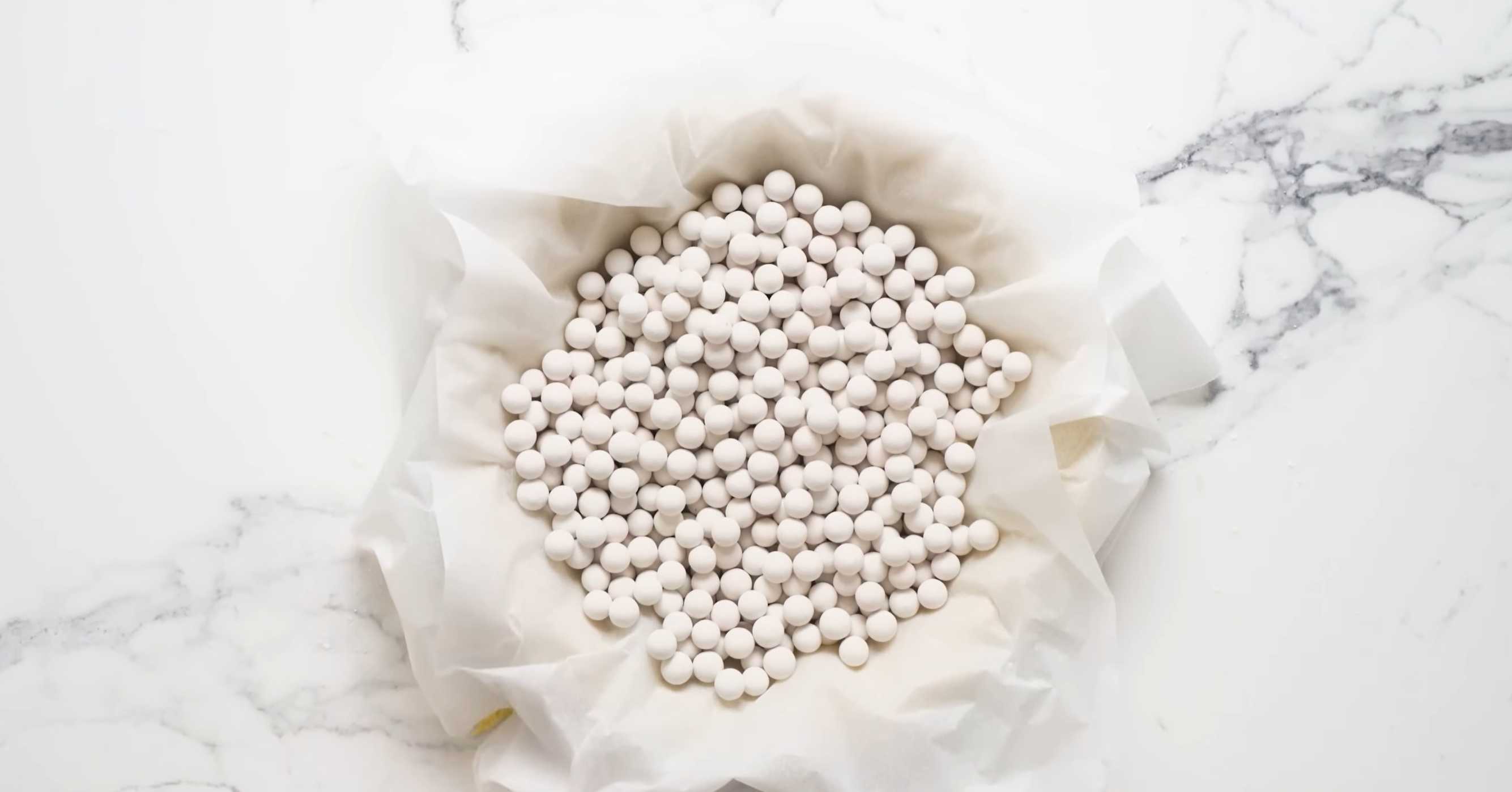 Накройте форму с тестом двумя листами бумаги для выпечки и насыпьте поверх бумаги наполнитель – сухие рис или фасоль, чтобы они заполнили форму вместо начинки. Семейный мясной пирог-Шаг 14