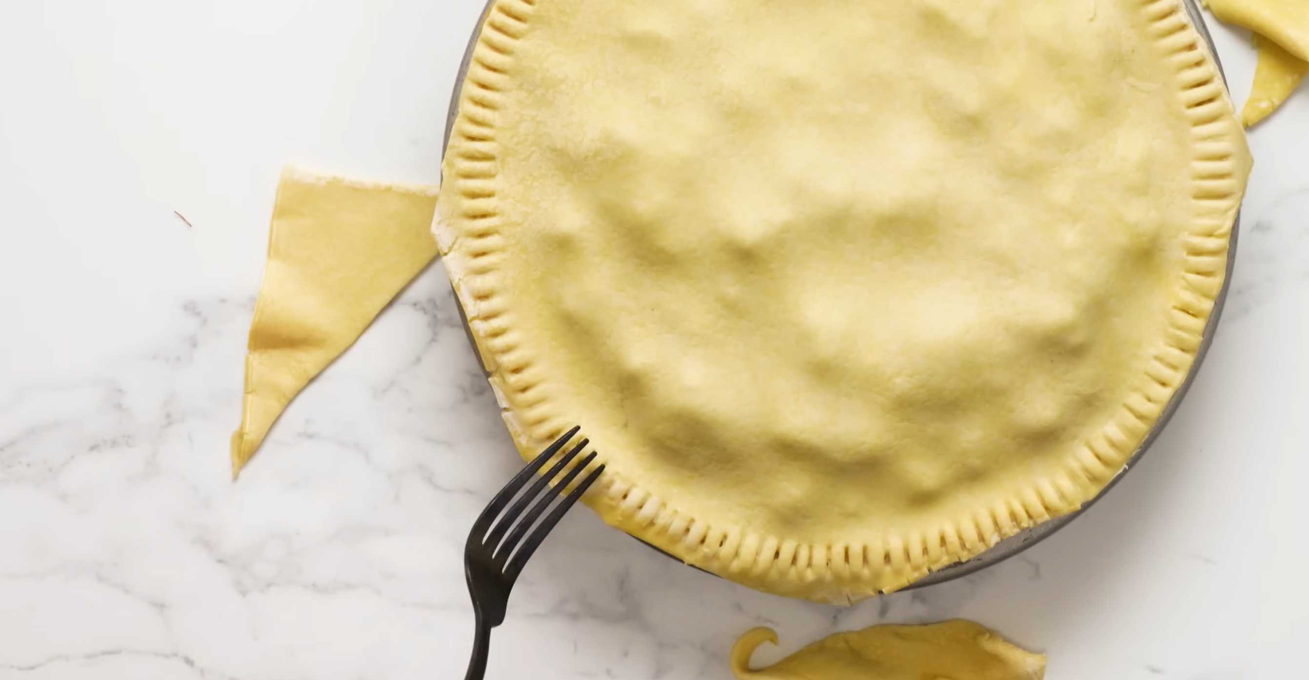 Накройте пирог листом слоеного теста, обрежьте края и прижмите их вилкой. Семейный мясной пирог-Шаг 17