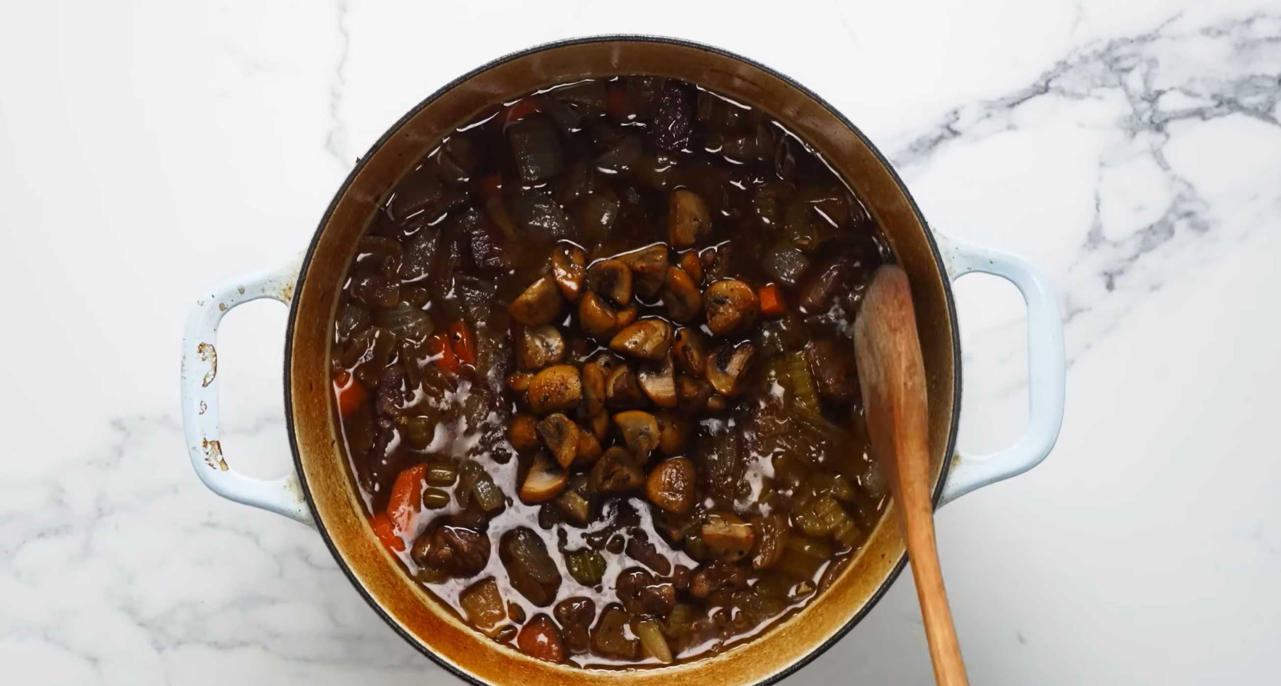 Добавьте в кастрюлю грибы, перемешайте и поставьте в духовку еще на час. Семейный мясной пирог-Шаг 8