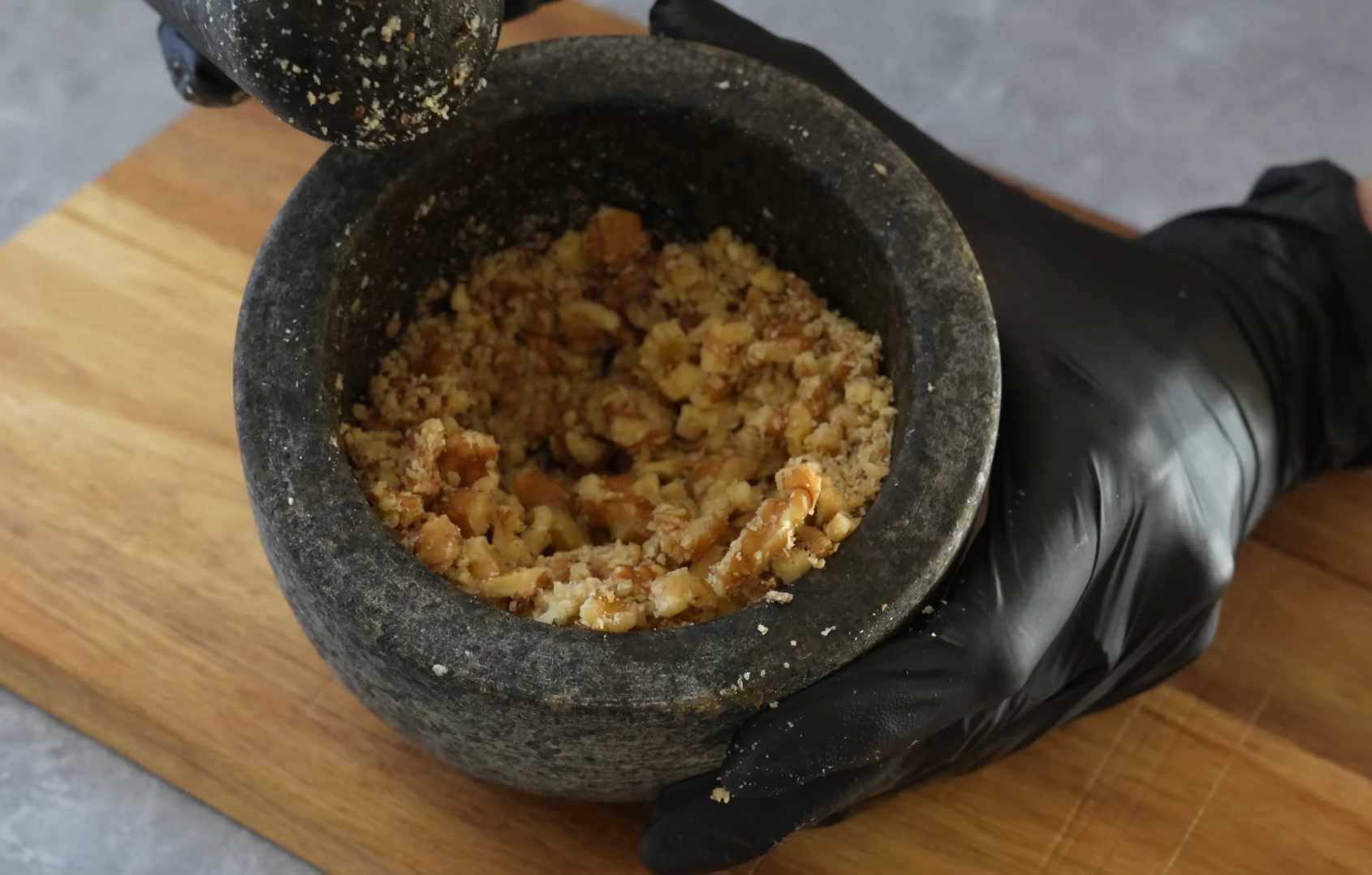 Приготовьте начинку: Измельчите грецкие орехи в ступке или блендере. Шарики из сыра и бекона-Шаг 3