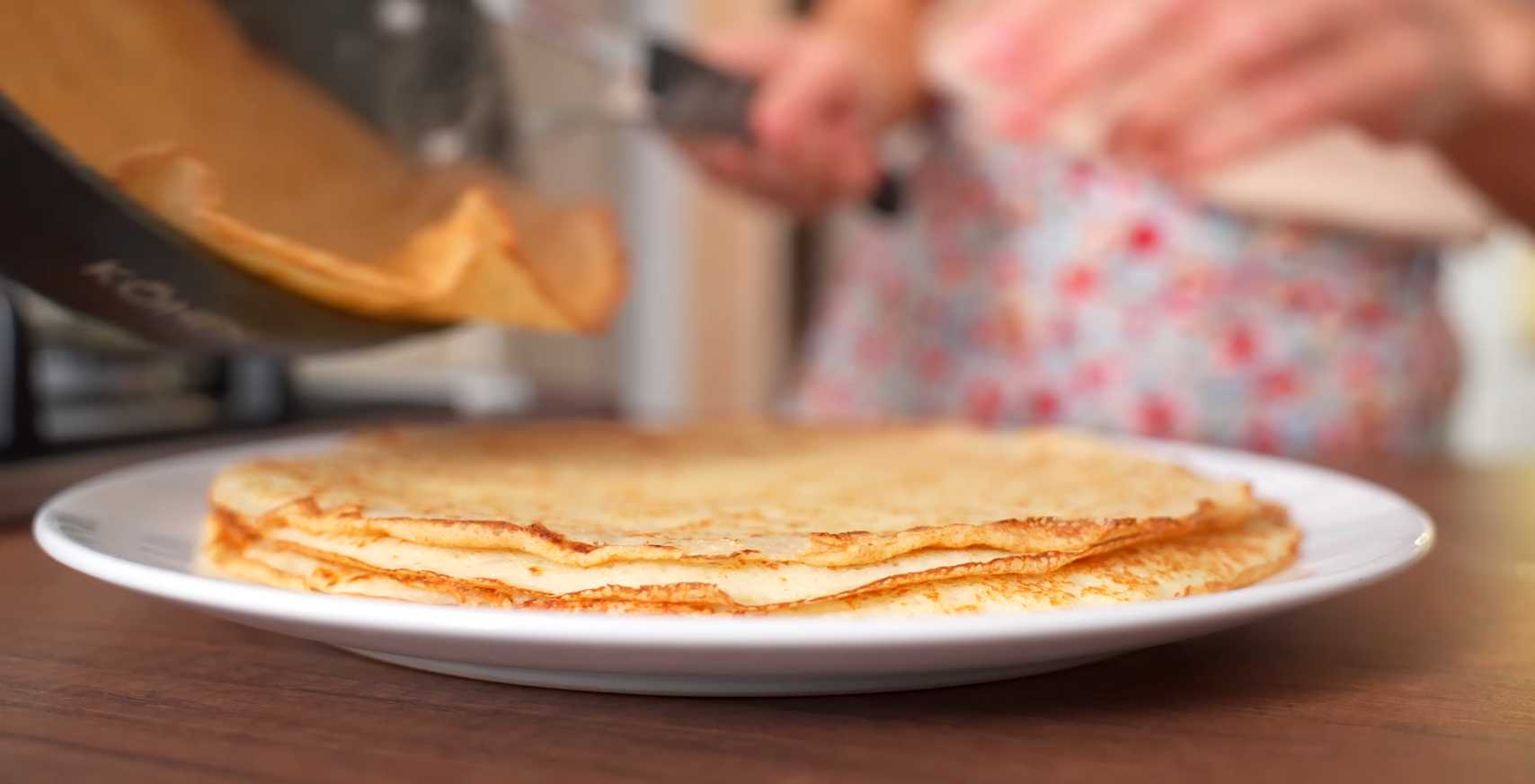 Обжарьте блины: Разогрейте сковороду и смажьте ее маслом. Вылейте порцию теста и равномерно распределите его. Обжаривайте до золотистой корочки с обеих сторон. Выложите на тарелку. Блинчики с курицей и грибами-Шаг 6