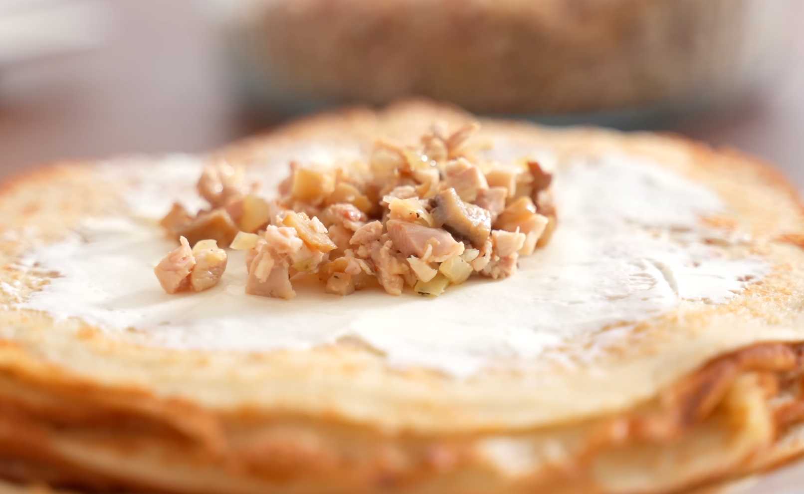 Соберите блинчики: На каждый блин выложите ложку сыра, затем — ложку начинки. Блинчики с курицей и грибами-Шаг 12