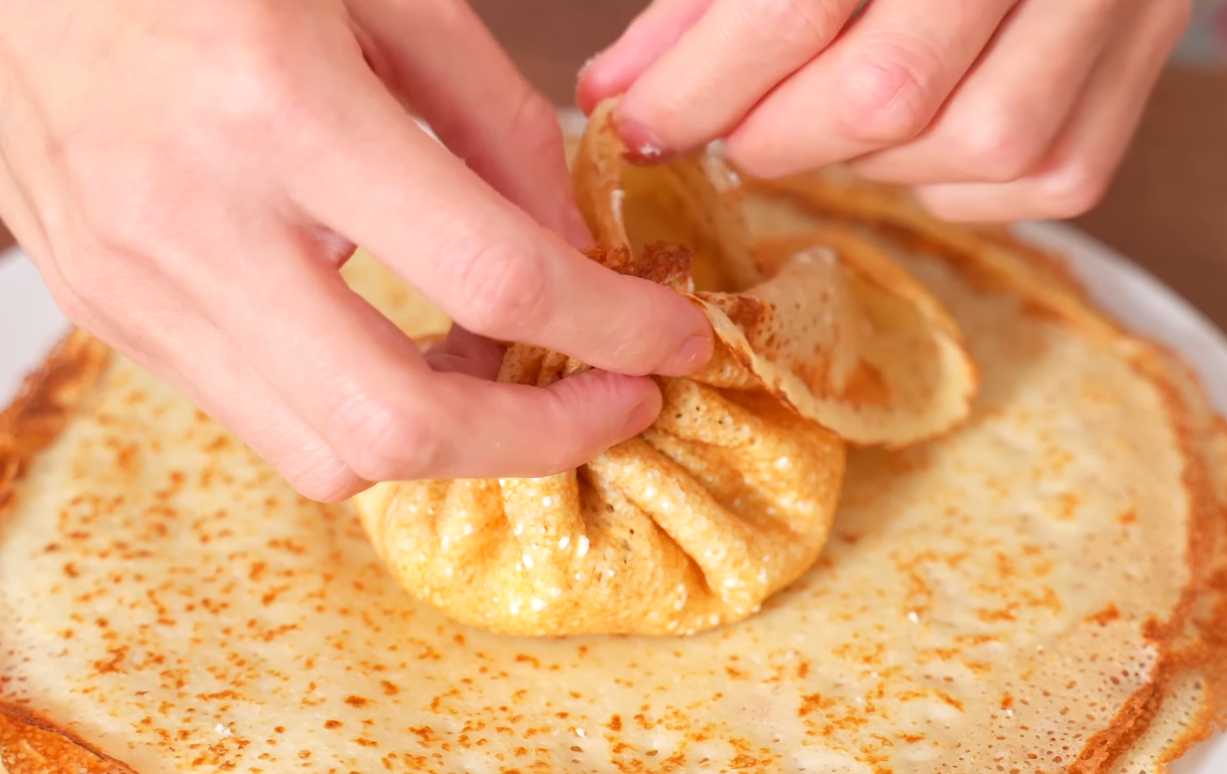 Соберите края блина в центр, чтобы получился мешочек. Блинчики с курицей и грибами-Шаг 13