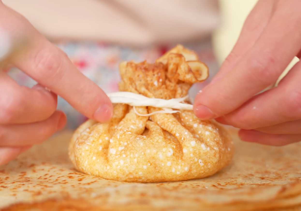 Завяжите и подавайте: Аккуратно завяжите верхушку блинчика сулугуни или зеленым луком. Блинчики с курицей и грибами-Шаг 14