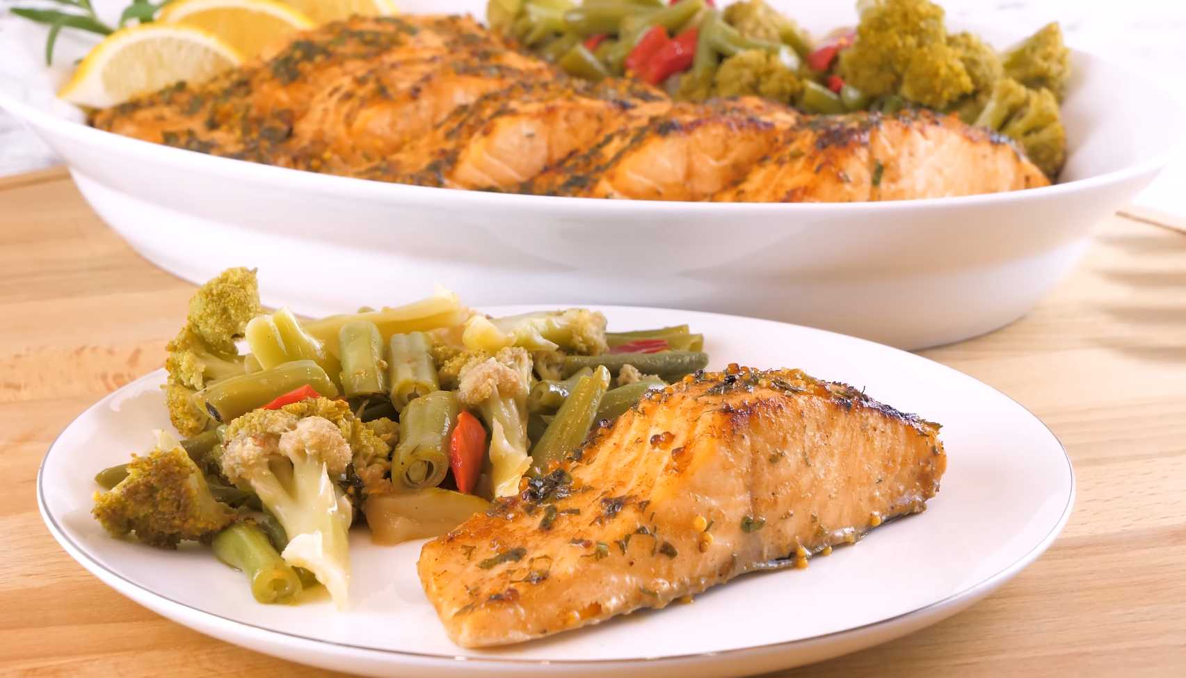 Подготовьте гарнир: Нарежьте брокколи и цветную капусту на соцветия. Нарежьте помидоры черри пополам. Обжарьте овощи на сковороде до готовности. Запечённый лосось с овощами-Шаг 6