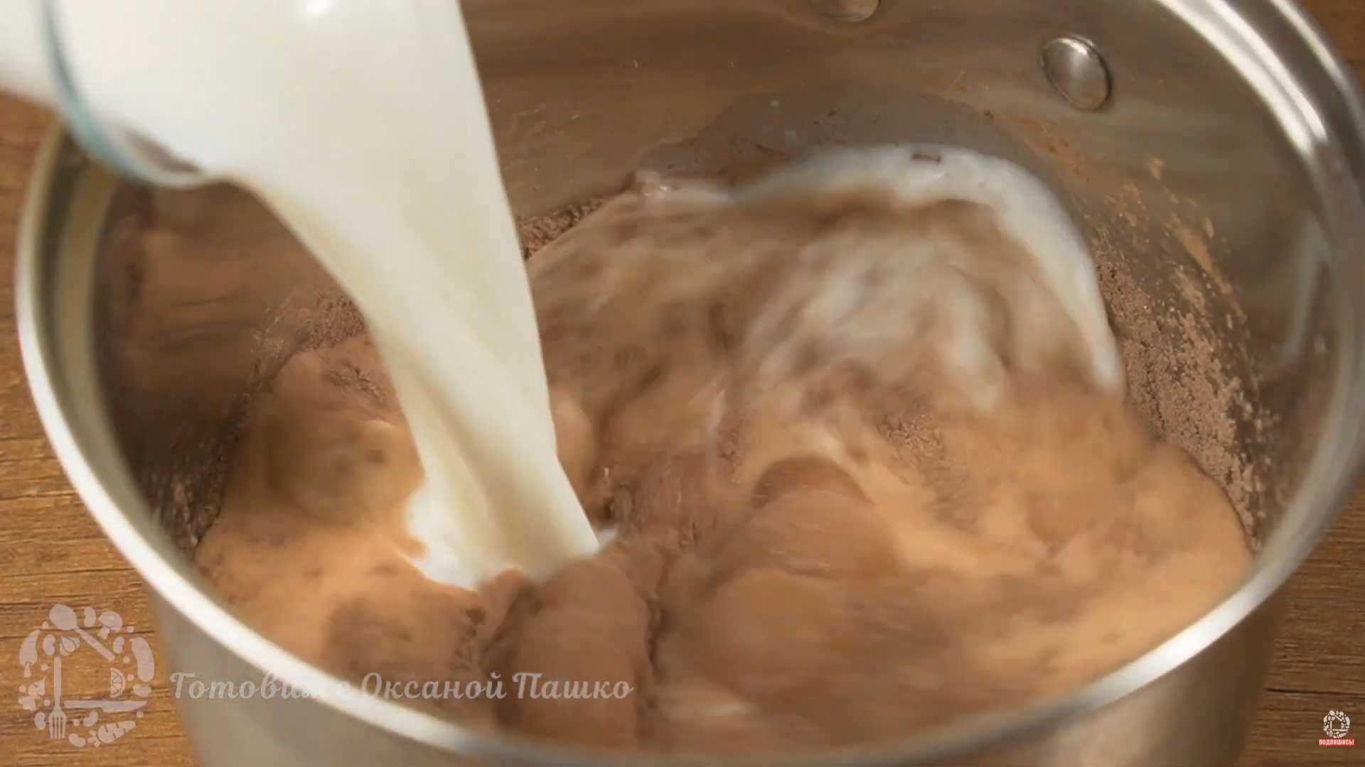 Постепенно влейте молоко, постоянно перемешивая венчиком, чтобы не образовались комочки. Поставьте сотейник на средний огонь и готовьте, непрерывно помешивая. Шоколадный пудинг-Шаг 3